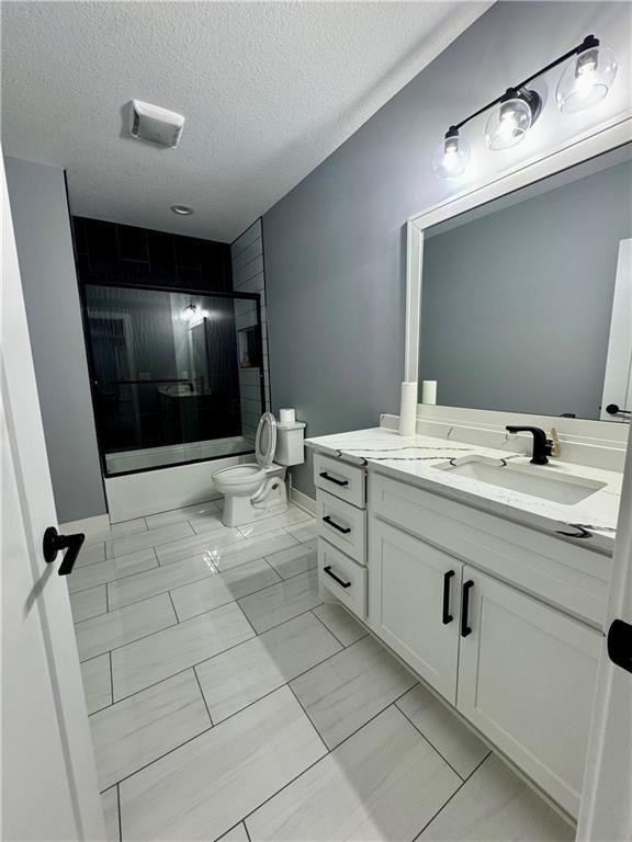 5443 N 101st Ter, Kansas City, KS 66109 - bathroom featuring vanity, combined bath / shower with glass door, and a textured ceiling
