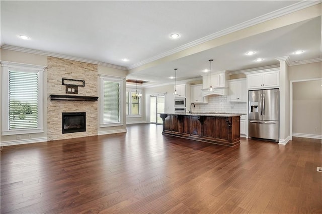 3912 SW Odell Dr, Lees Summit, MO 64082 - kitchen featuring stainless steel appliances, open floor plan, a breakfast bar, dark wood-style floors, and backsplash