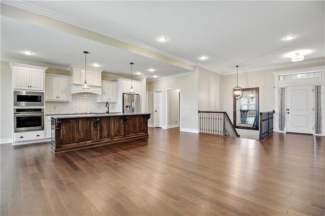 3912 SW Odell Dr, Lees Summit, MO 64082 - kitchen with appliances with stainless steel finishes, dark wood-type flooring, a kitchen island with sink, tasteful backsplash, and custom range hood