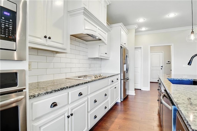 3912 SW Odell Dr, Lees Summit, MO 64082 - kitchen with appliances with stainless steel finishes, custom exhaust hood, ornamental molding, tasteful backsplash, and white cabinets