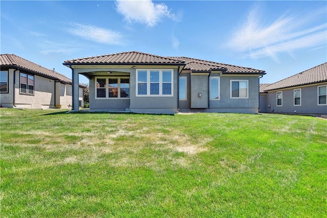 3912 SW Odell Dr, Lees Summit, MO 64082 - back of house featuring a tile roof, stucco siding, and a lawn