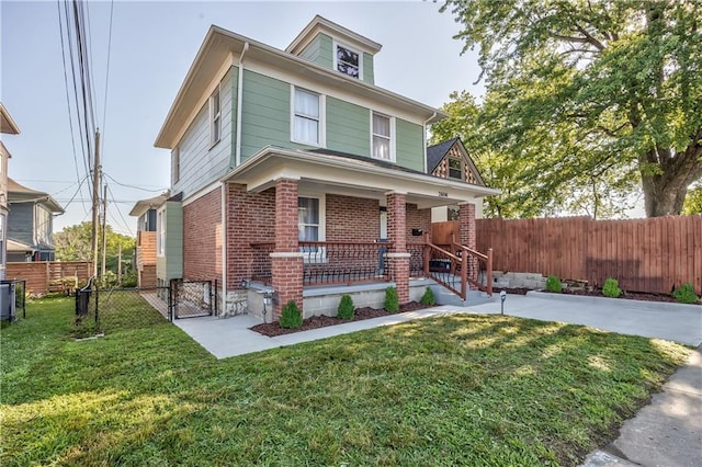 2606 Smart Ave, Kansas City, MO 64124 - american foursquare style home with brick siding, covered porch, and a gate