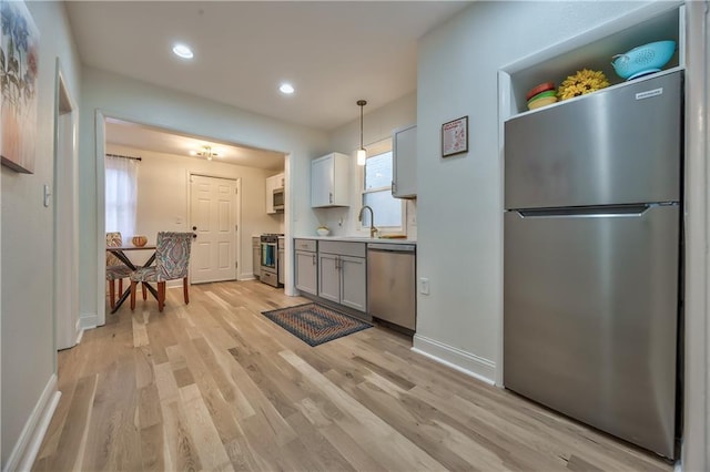 2606 Smart Ave, Kansas City, MO 64124 - kitchen with stainless steel appliances, light wood-style flooring, recessed lighting, pendant lighting, and light countertops