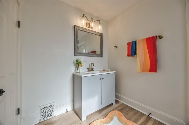2606 Smart Ave, Kansas City, MO 64124 - bathroom with vanity and wood finished floors