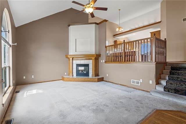 913 N Cochise Ave, Independence, MO 64056 - unfurnished living room featuring high vaulted ceiling, ceiling fan, stairs, a fireplace, and carpet flooring