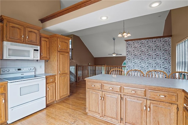 913 N Cochise Ave, Independence, MO 64056 - kitchen with white appliances, a chandelier, vaulted ceiling, light wood-type flooring, and tasteful backsplash