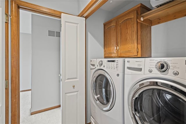 913 N Cochise Ave, Independence, MO 64056 - laundry room featuring washer and clothes dryer, cabinet space, and light colored carpet
