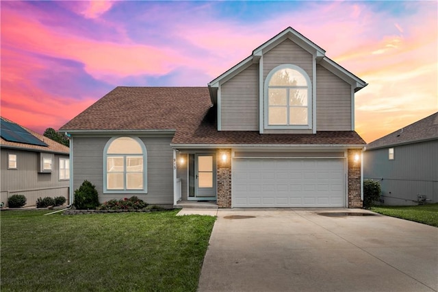 913 N Cochise Ave, Independence, MO 64056 - traditional-style home with an attached garage, concrete driveway, a front lawn, brick siding, and a shingled roof