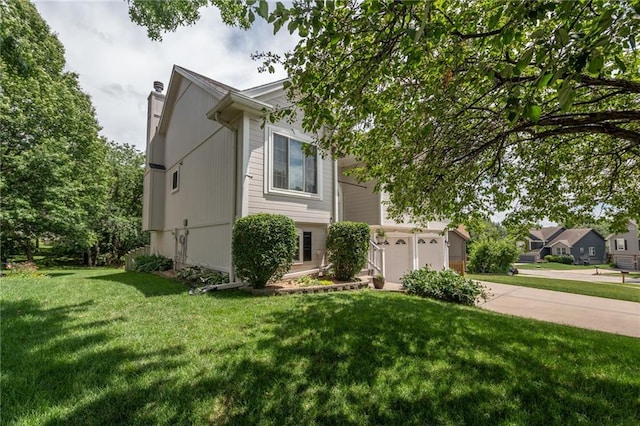 207 Woodhaven Dr, Smithville, MO 64089 - view of front facade featuring concrete driveway, a chimney, a front lawn, and a garage