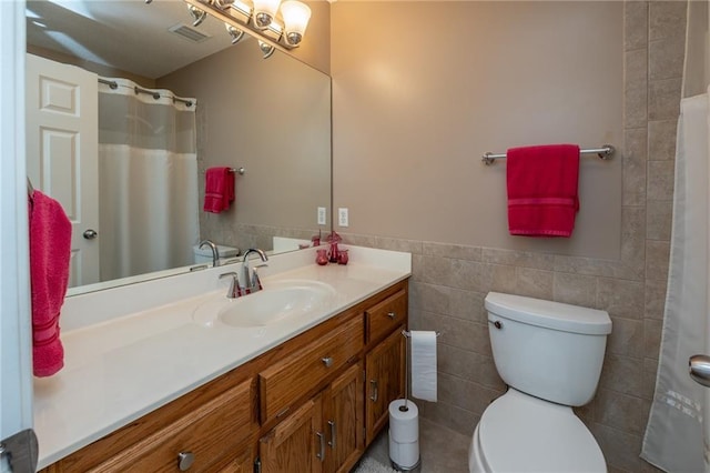 207 Woodhaven Dr, Smithville, MO 64089 - bathroom with vanity, tile walls, a wainscoted wall, and a shower with curtain