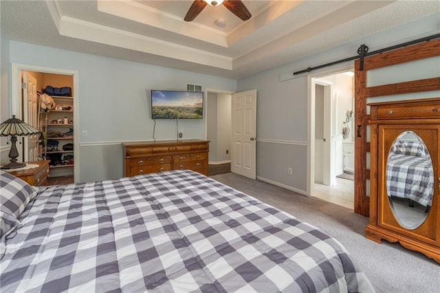207 Woodhaven Dr, Smithville, MO 64089 - bedroom featuring carpet, a tray ceiling, a walk in closet, a barn door, and crown molding