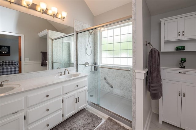 207 Woodhaven Dr, Smithville, MO 64089 - bathroom featuring a stall shower, lofted ceiling, double vanity, and a wainscoted wall