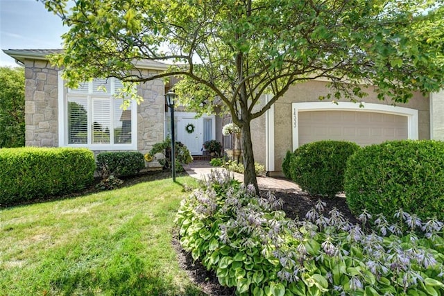 14333 Norwood St, Leawood, KS 66224 - obstructed view of property featuring stucco siding, a front yard, stone siding, and a garage