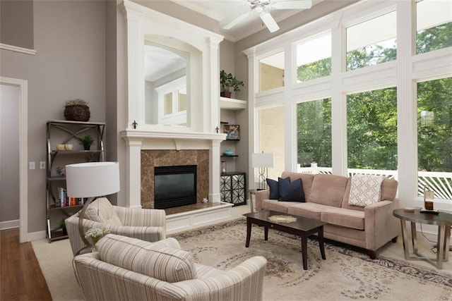 14333 Norwood St, Leawood, KS 66224 - living area featuring a high end fireplace, wood finished floors, a ceiling fan, crown molding, and a high ceiling