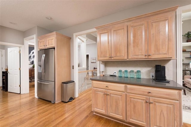 14333 Norwood St, Leawood, KS 66224 - kitchen featuring stainless steel fridge, dark countertops, light wood finished floors, and tasteful backsplash