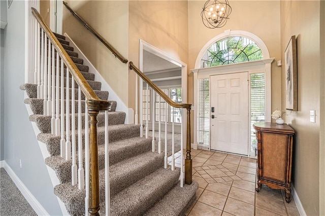 5713 NE Sapphire Ct, Lees Summit, MO 64064 - tiled foyer entrance with stairs, a high ceiling, and a chandelier