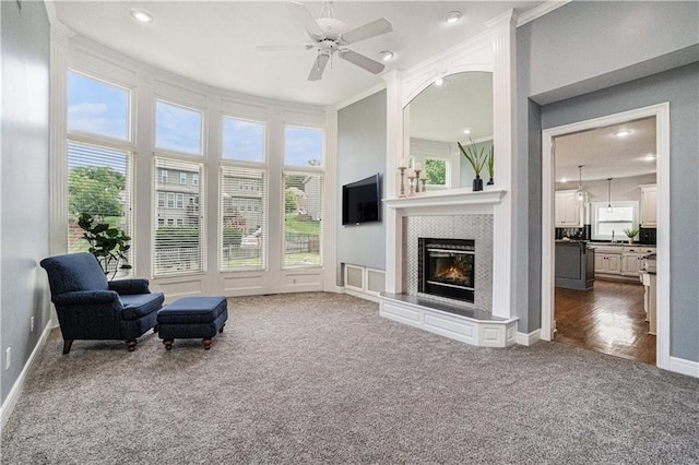 5713 NE Sapphire Ct, Lees Summit, MO 64064 - living area with carpet, a glass covered fireplace, ceiling fan, ornamental molding, and recessed lighting