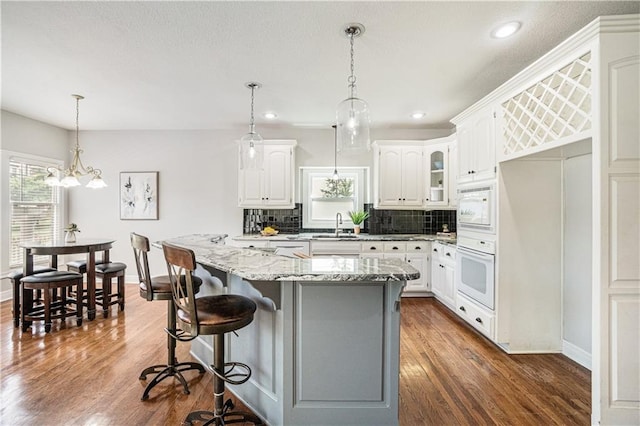 5713 NE Sapphire Ct, Lees Summit, MO 64064 - kitchen featuring white appliances, plenty of natural light, backsplash, white cabinets, and recessed lighting