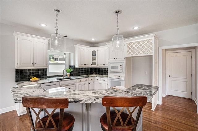 5713 NE Sapphire Ct, Lees Summit, MO 64064 - kitchen featuring white appliances, light stone counters, white cabinets, decorative backsplash, and recessed lighting