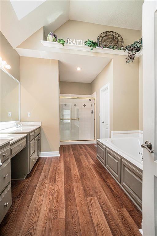 5713 NE Sapphire Ct, Lees Summit, MO 64064 - full bathroom featuring a shower with door, vanity, a bath, and wood finished floors