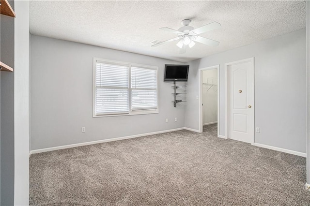 5713 NE Sapphire Ct, Lees Summit, MO 64064 - unfurnished bedroom featuring carpet flooring, a textured ceiling, a spacious closet, and ceiling fan
