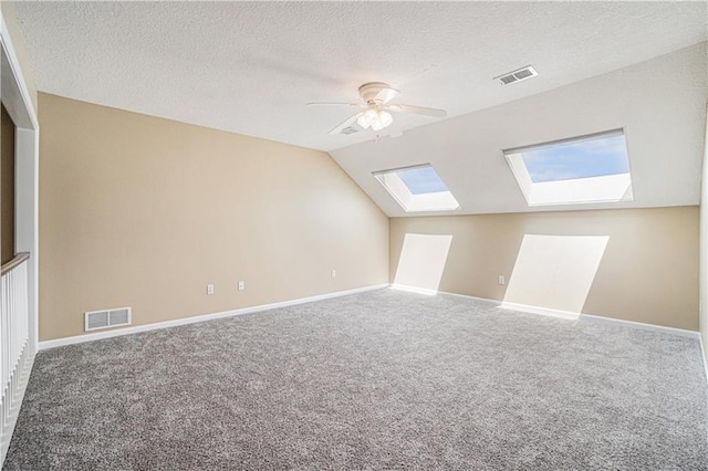 5713 NE Sapphire Ct, Lees Summit, MO 64064 - bonus room featuring a skylight, carpet, lofted ceiling, a textured ceiling, and ceiling fan