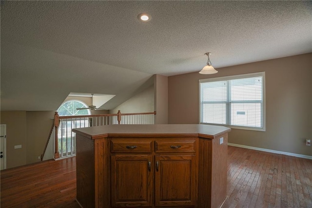 17586 W 161st St, Olathe, KS 66062 - kitchen with dark wood-style floors, a textured ceiling, light countertops, a kitchen island, and brown cabinetry