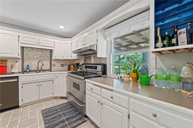 8751 Goddard St, Overland Park, KS 66214 - kitchen with appliances with stainless steel finishes, under cabinet range hood, white cabinetry, decorative backsplash, and light countertops