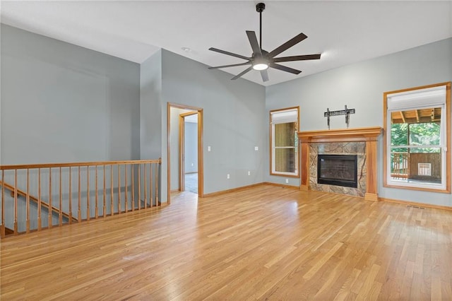 12324 S Clinton St, Olathe, KS 66061 - unfurnished living room with wood finished floors, a ceiling fan, and a high end fireplace