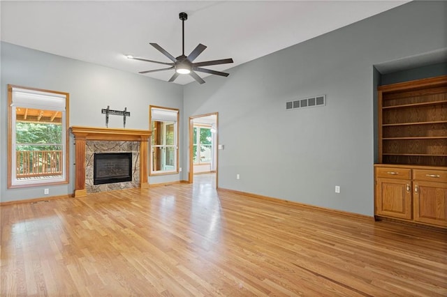12324 S Clinton St, Olathe, KS 66061 - unfurnished living room featuring ceiling fan, light wood-type flooring, a high end fireplace, and vaulted ceiling