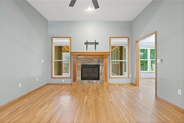 12324 S Clinton St, Olathe, KS 66061 - unfurnished living room with a stone fireplace, wood finished floors, and a ceiling fan