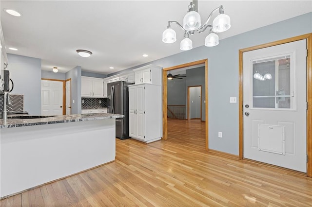 12324 S Clinton St, Olathe, KS 66061 - kitchen with stainless steel appliances, white cabinetry, stone countertops, light wood finished floors, and backsplash