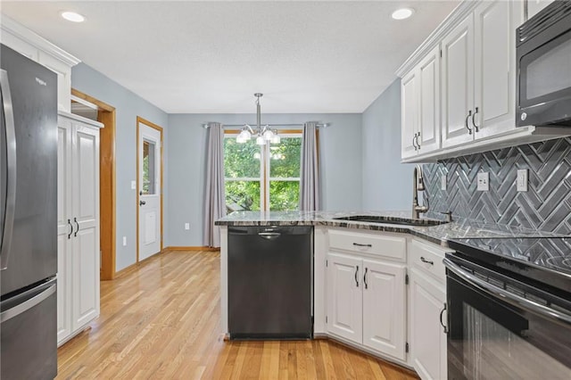 12324 S Clinton St, Olathe, KS 66061 - kitchen with black appliances, a peninsula, a chandelier, white cabinets, and recessed lighting