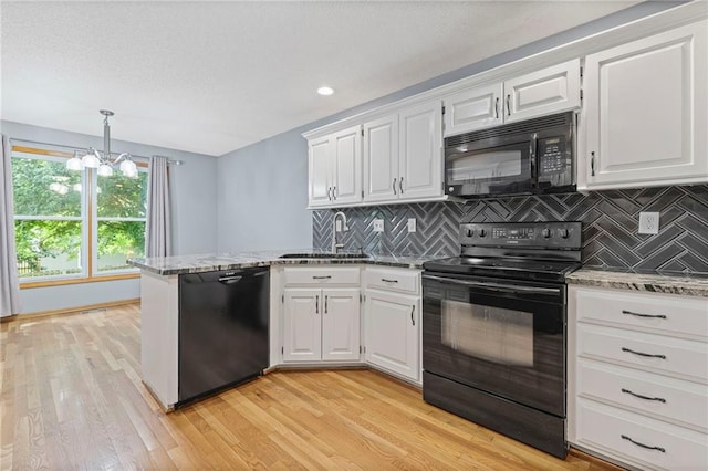 12324 S Clinton St, Olathe, KS 66061 - kitchen with black appliances, a peninsula, backsplash, light wood-style flooring, and a textured ceiling