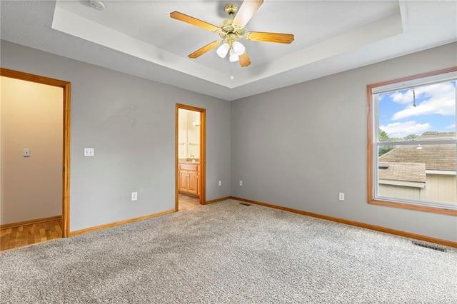 12324 S Clinton St, Olathe, KS 66061 - unfurnished room featuring a raised ceiling, light colored carpet, and a ceiling fan