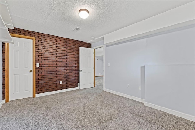 12324 S Clinton St, Olathe, KS 66061 - unfurnished room featuring brick wall, a textured ceiling, and carpet flooring