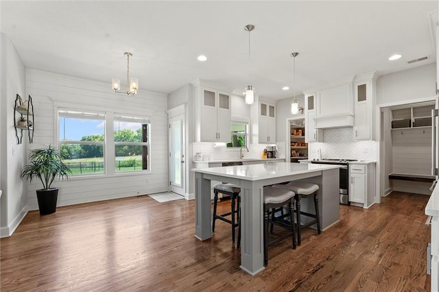 2312 SW Morris Dr, Lees Summit, MO 64082 - kitchen featuring electric range, light countertops, decorative backsplash, a breakfast bar, and white cabinets