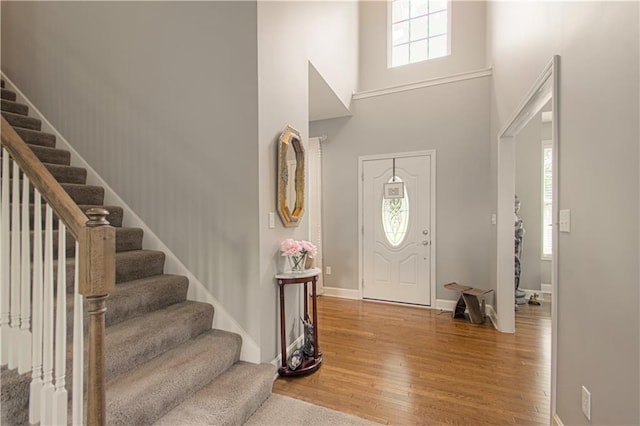 908 Pca Rd, Warrensburg, MO 64093 - entryway featuring healthy amount of natural light, wood finished floors, stairway, and a high ceiling