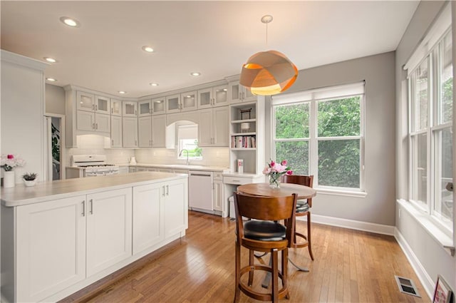 908 Pca Rd, Warrensburg, MO 64093 - kitchen featuring white range with gas stovetop, dishwashing machine, plenty of natural light, light countertops, and recessed lighting
