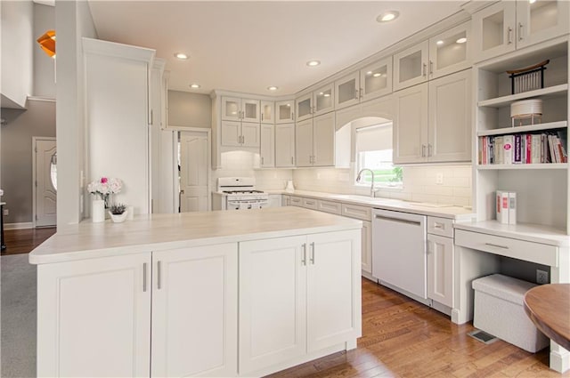 908 Pca Rd, Warrensburg, MO 64093 - kitchen featuring white appliances, a peninsula, light countertops, wood finished floors, and recessed lighting