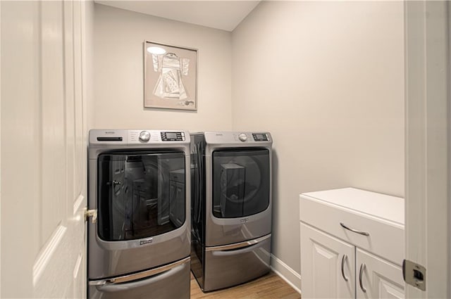 908 Pca Rd, Warrensburg, MO 64093 - laundry room featuring cabinet space, separate washer and dryer, and wood finished floors