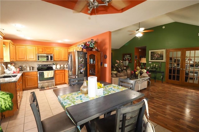329 W 26th Ln, Eudora, KS 66025 - dining space featuring ceiling fan, light tile patterned floors, and vaulted ceiling