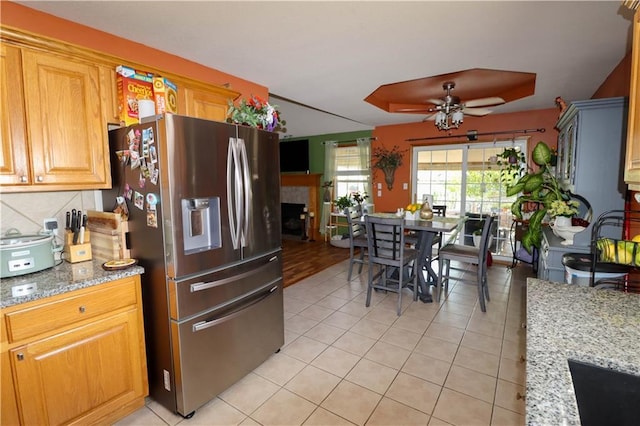 329 W 26th Ln, Eudora, KS 66025 - kitchen with stainless steel fridge with ice dispenser, light tile patterned floors, a ceiling fan, light stone countertops, and tasteful backsplash