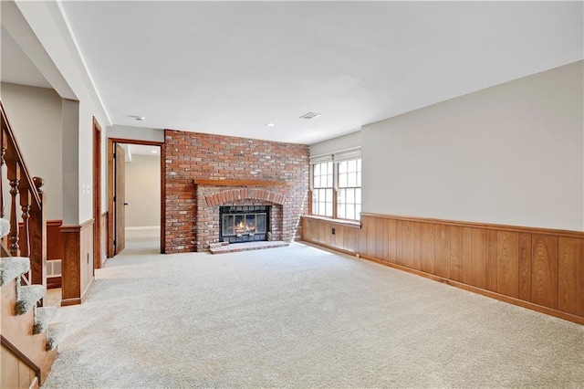 12303 W 105th Ter, Overland Park, KS 66215 - unfurnished living room with wainscoting, stairway, carpet flooring, a brick fireplace, and wood walls