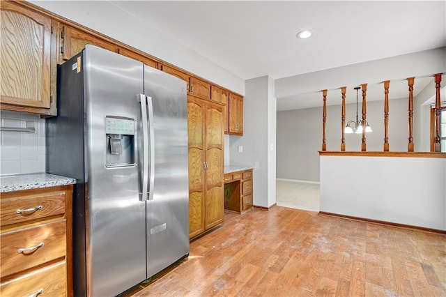 12303 W 105th Ter, Overland Park, KS 66215 - kitchen with stainless steel fridge with ice dispenser, brown cabinets, light wood-style flooring, recessed lighting, and tasteful backsplash