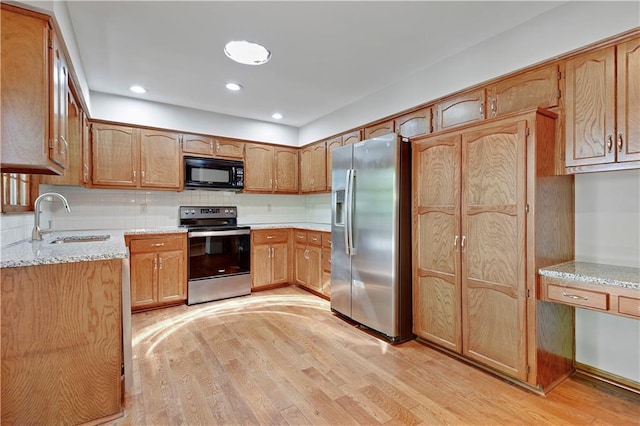 12303 W 105th Ter, Overland Park, KS 66215 - kitchen with stainless steel appliances, light wood-style floors, backsplash, light stone counters, and recessed lighting