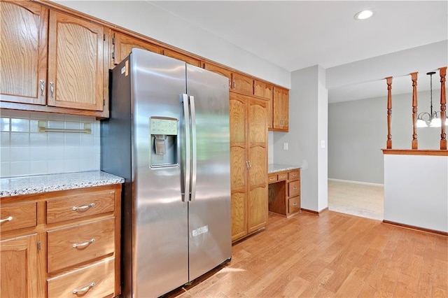 12303 W 105th Ter, Overland Park, KS 66215 - kitchen with stainless steel fridge with ice dispenser, light wood-style flooring, recessed lighting, light stone countertops, and brown cabinets