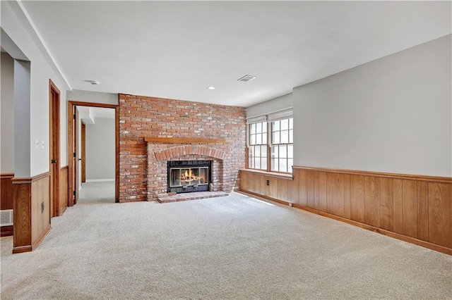 12303 W 105th Ter, Overland Park, KS 66215 - unfurnished living room with wainscoting, carpet floors, wood walls, and a brick fireplace