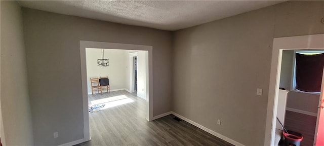 5107 E 26th St, Kansas City, MO 64127 - hallway featuring dark wood-style floors and a textured ceiling