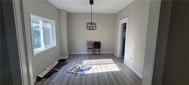 5107 E 26th St, Kansas City, MO 64127 - unfurnished dining area featuring wood finished floors and a baseboard radiator